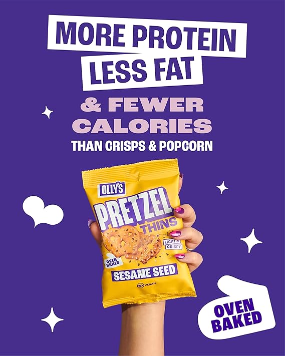 A hand holding a yellow bag of Ollie's Pretzel Thins Sesame Seed snack 'MORE PROTEIN LESS FAT & FEWER CALORIES THAN CRISPS & POPCORN' and 'OVEN BAKED'.