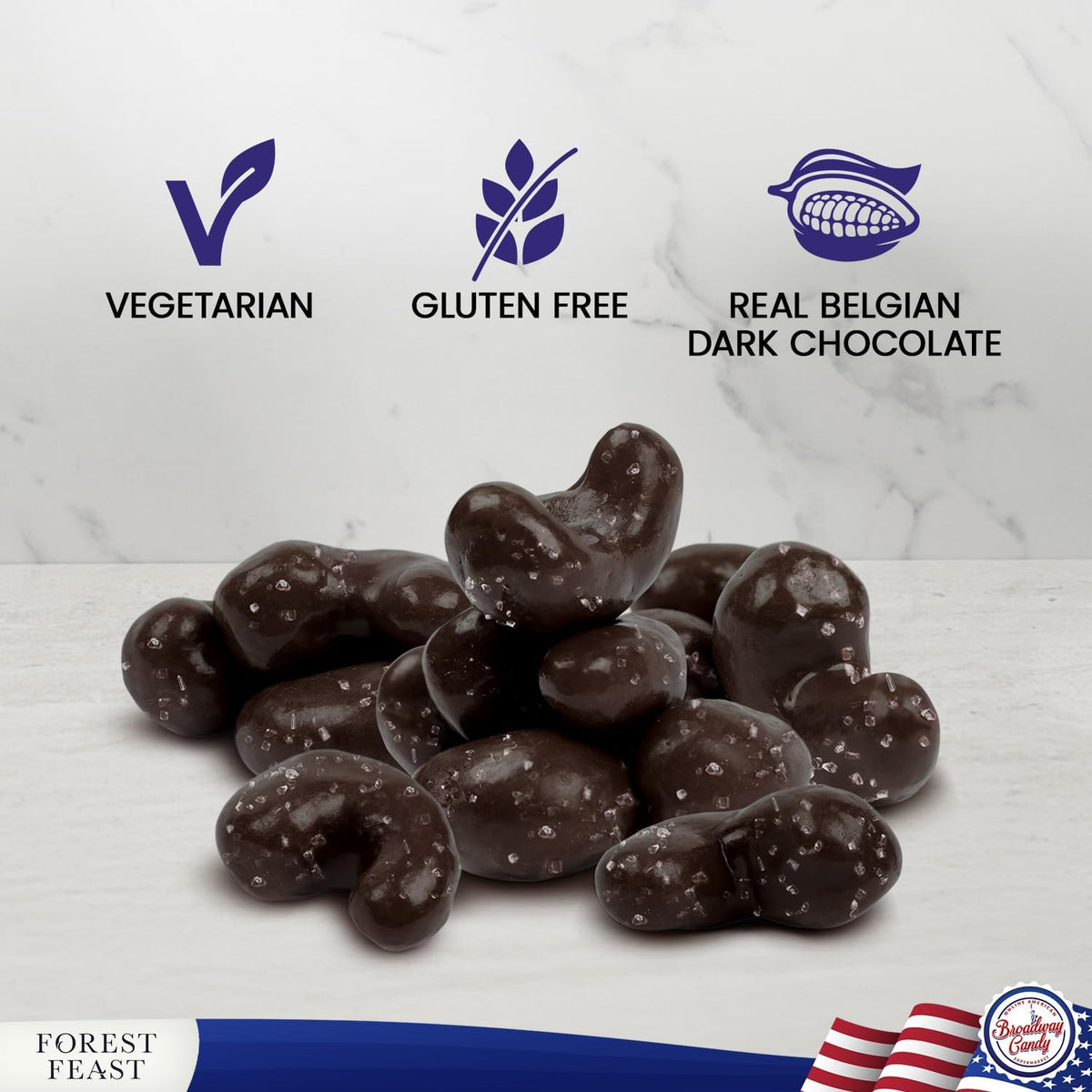 A pile of dark chocolate-covered cashews with visible coarse salt crystals, shown on a light marble-style surface with text badges reading Vegetarian, Gluten Free, and Real Belgian Dark Chocolate. A Forest Feast logo appears at the bottom left, and a small circular brand seal is at the bottom right.
