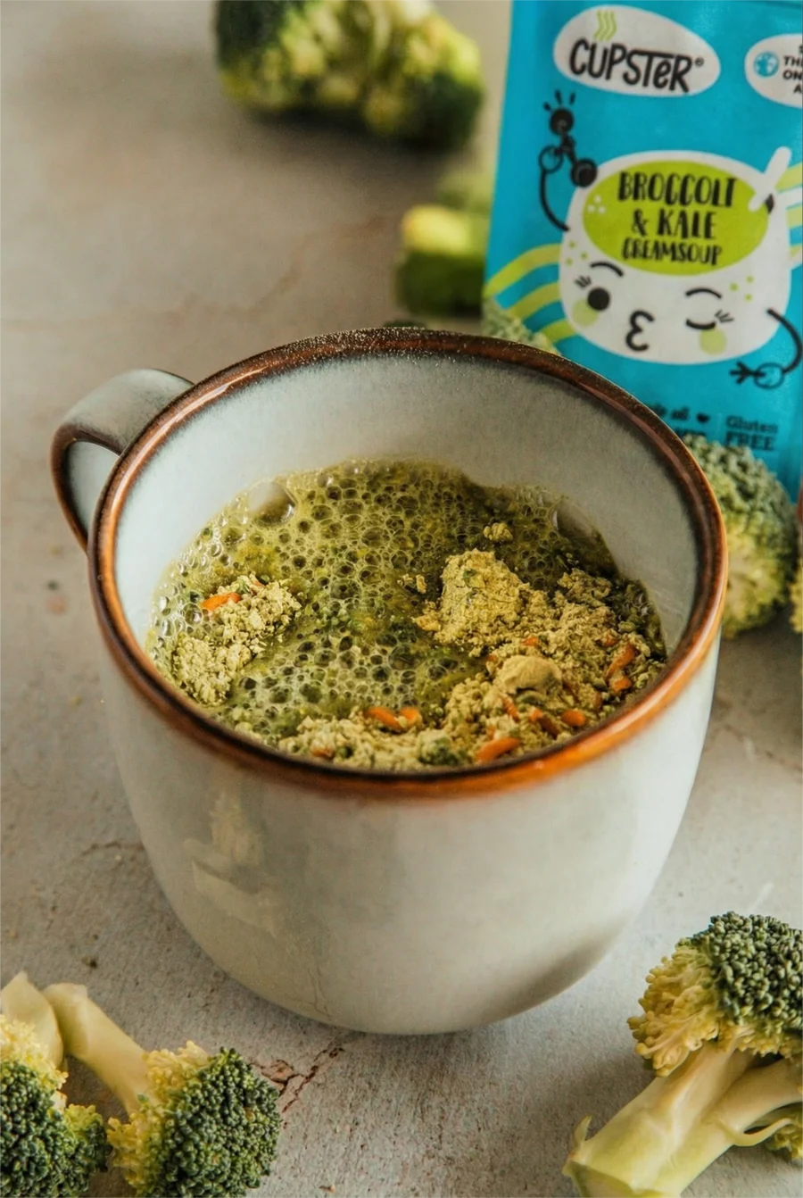 Cupster instant broccoli - kale cream soup in a mug showing the pwder being absorbed into the soup