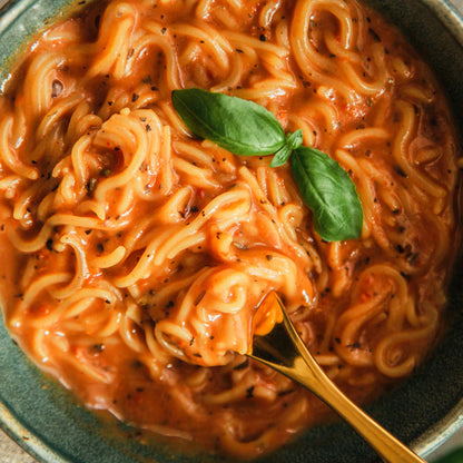 A top-down close-up of a bowl of cooked Cupster Instant Basilico Pasta 97g