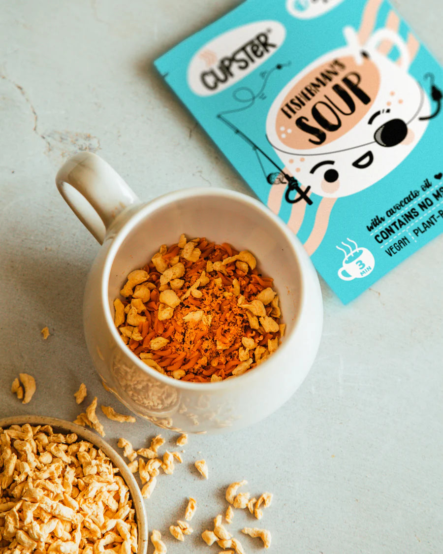 A white ceramic mug filled with Cupster instant fisherman's soup dried ingredients 