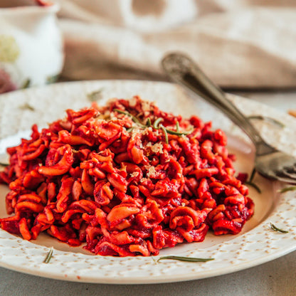 A close-up of a mound of red-sauce pasta  made using Mill & Folks - Gluten Free Buckwheat pasta fusilli.